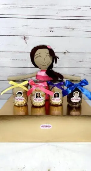 A doll sitting on top of a table next to jars.