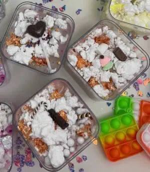 A table with several containers of popcorn and candy.