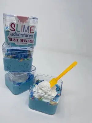A stack of blue jello with white frosting.