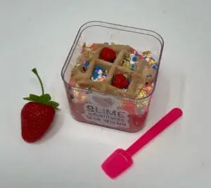 A strawberry and some other items are in a container.
