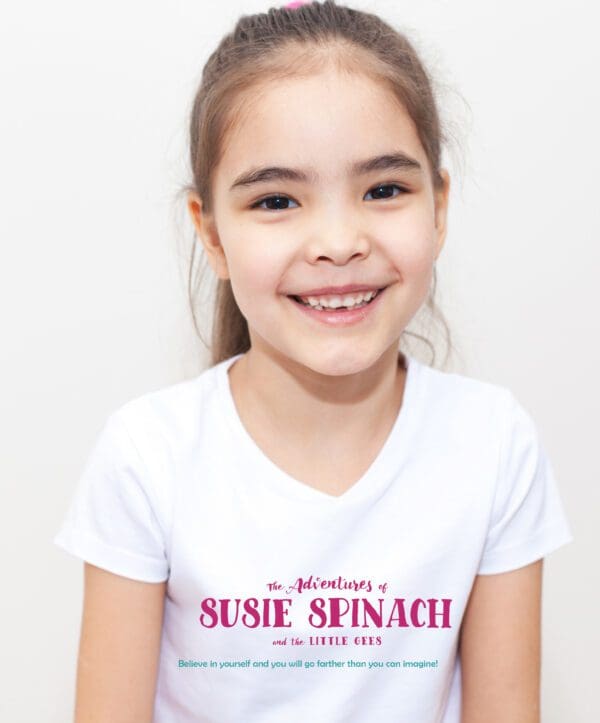 A young girl wearing a white shirt with the words " susie spinach ".