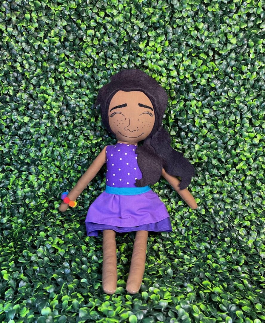A doll is laying on the ground in some bushes