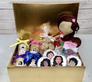 A box of cookies and chocolates with a doll
