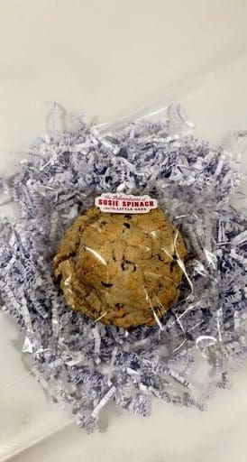 A cookie in plastic wrapper with a sticker on it.