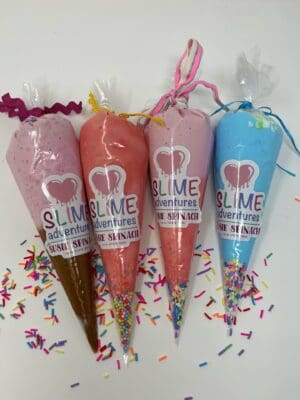 A group of four cones filled with different colored slime.