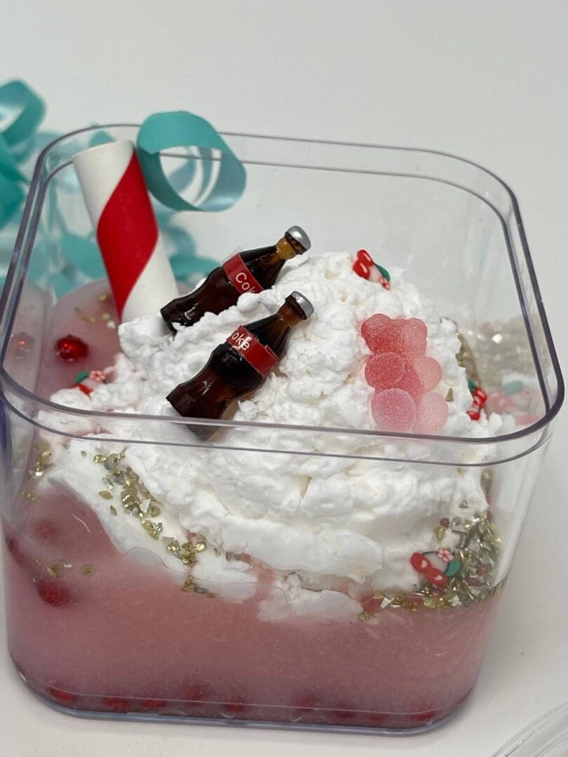 A plastic container with cake and candles in it.