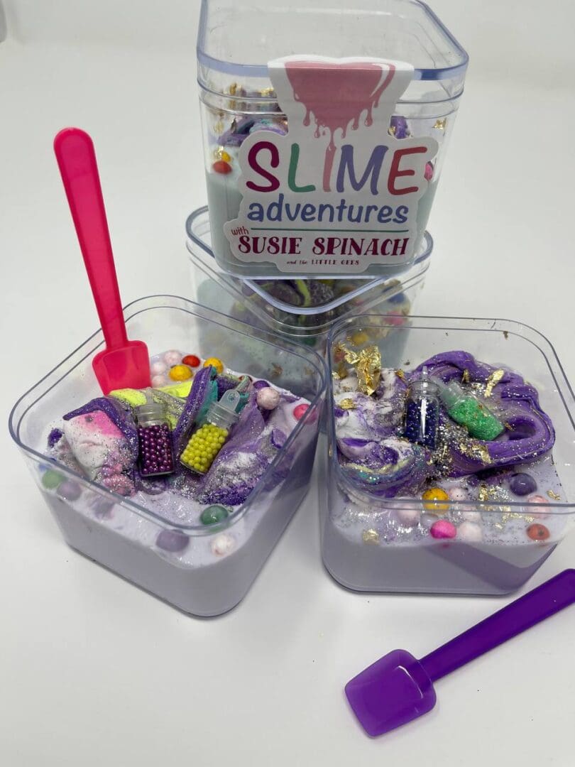 A table with two containers of slime and some other items.