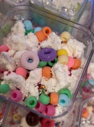 A plastic container filled with white rice and colorful cereal.