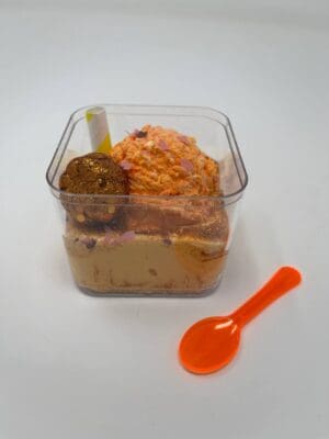 A plastic spoon and some food in a container