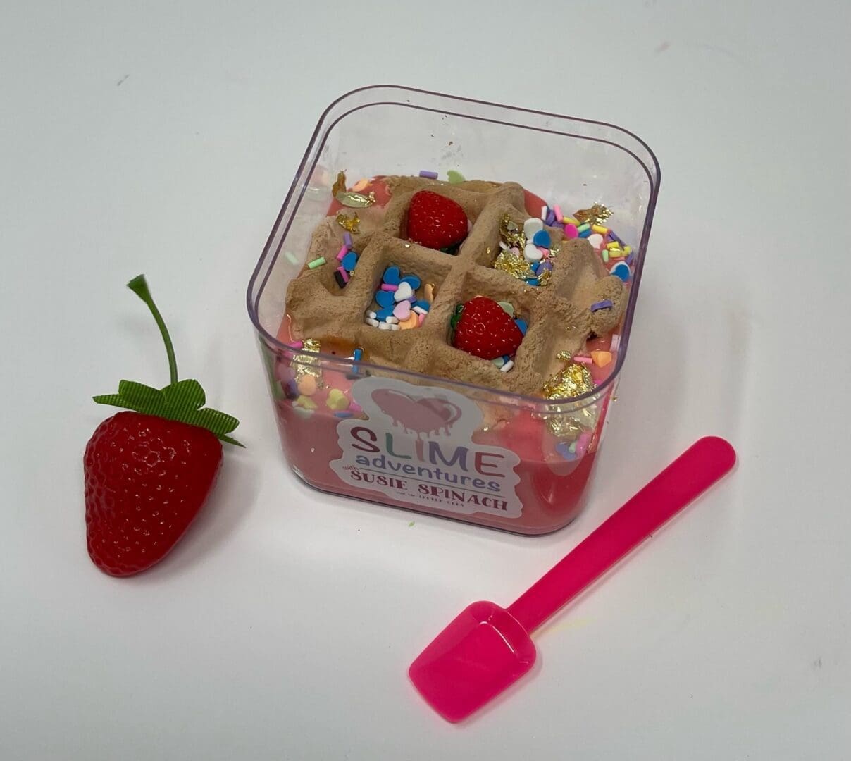A strawberry and some other items are in a container.