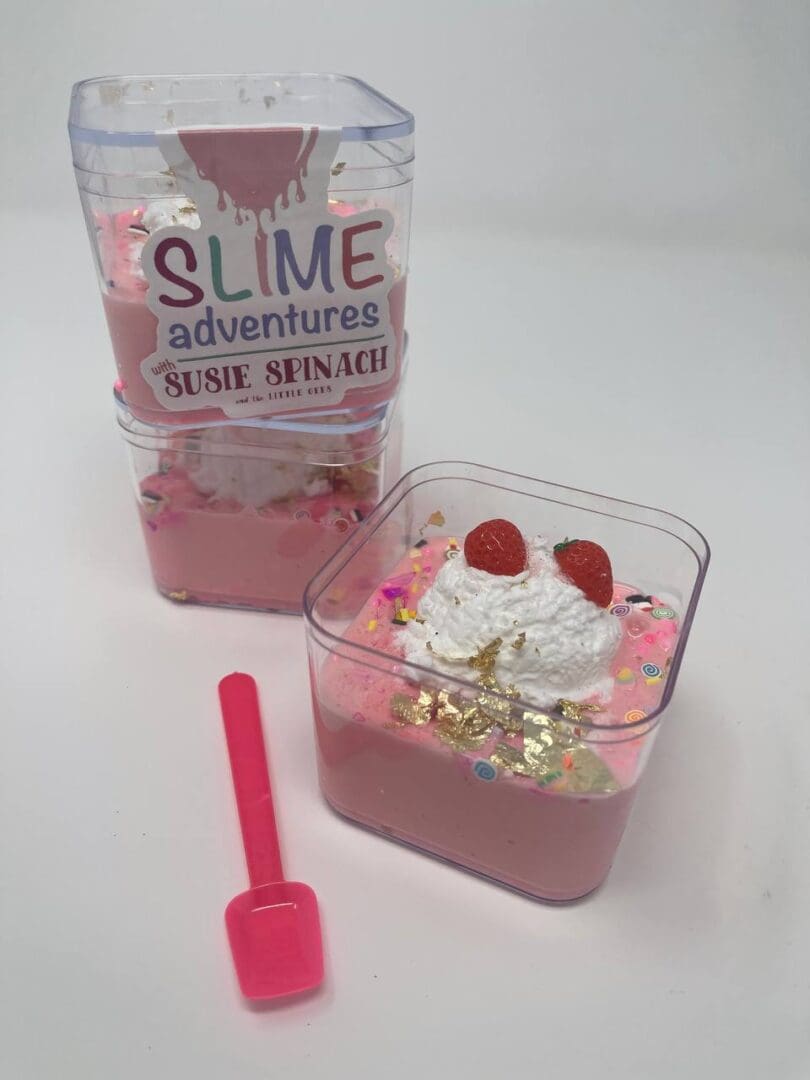 A pink container filled with food next to a bottle of slime.